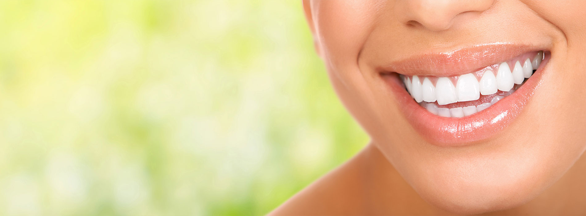 The image is a photograph of a woman with light skin, smiling at the camera. She appears to be in her late twenties or early thirties and has long hair. Her eyes are looking directly at the camera, and she is holding up her index finger near her mouth as if she s making a point or emphasizing something. The background is plain and light-colored, which suggests that this could be a stock photo used for various purposes such as advertising, personal branding, or lifestyle content.