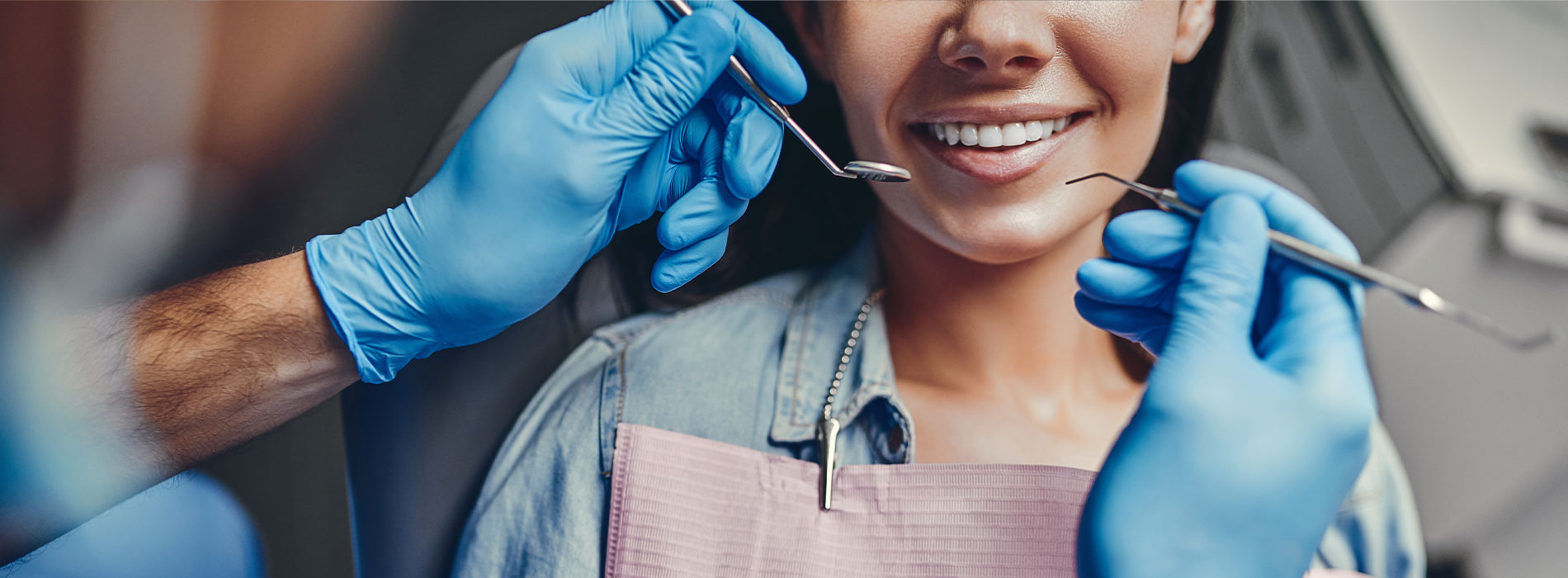 A well-lit reception area with a desk, computer monitor, and potted plant.