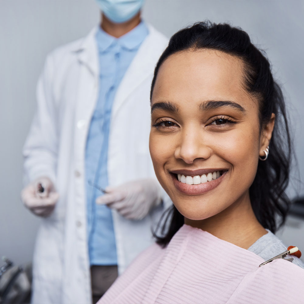 A dental professional is assisting a patient with a digital display of the patient s mouth, highlighting dental work in progress.
